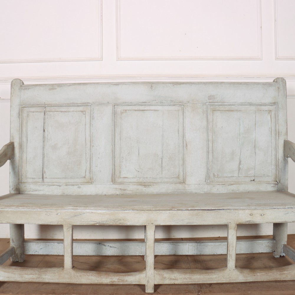 An 18th-century painted wooden tavern bench featuring a high back with three recessed panels, curved armrests, and lower stretchers. View IV