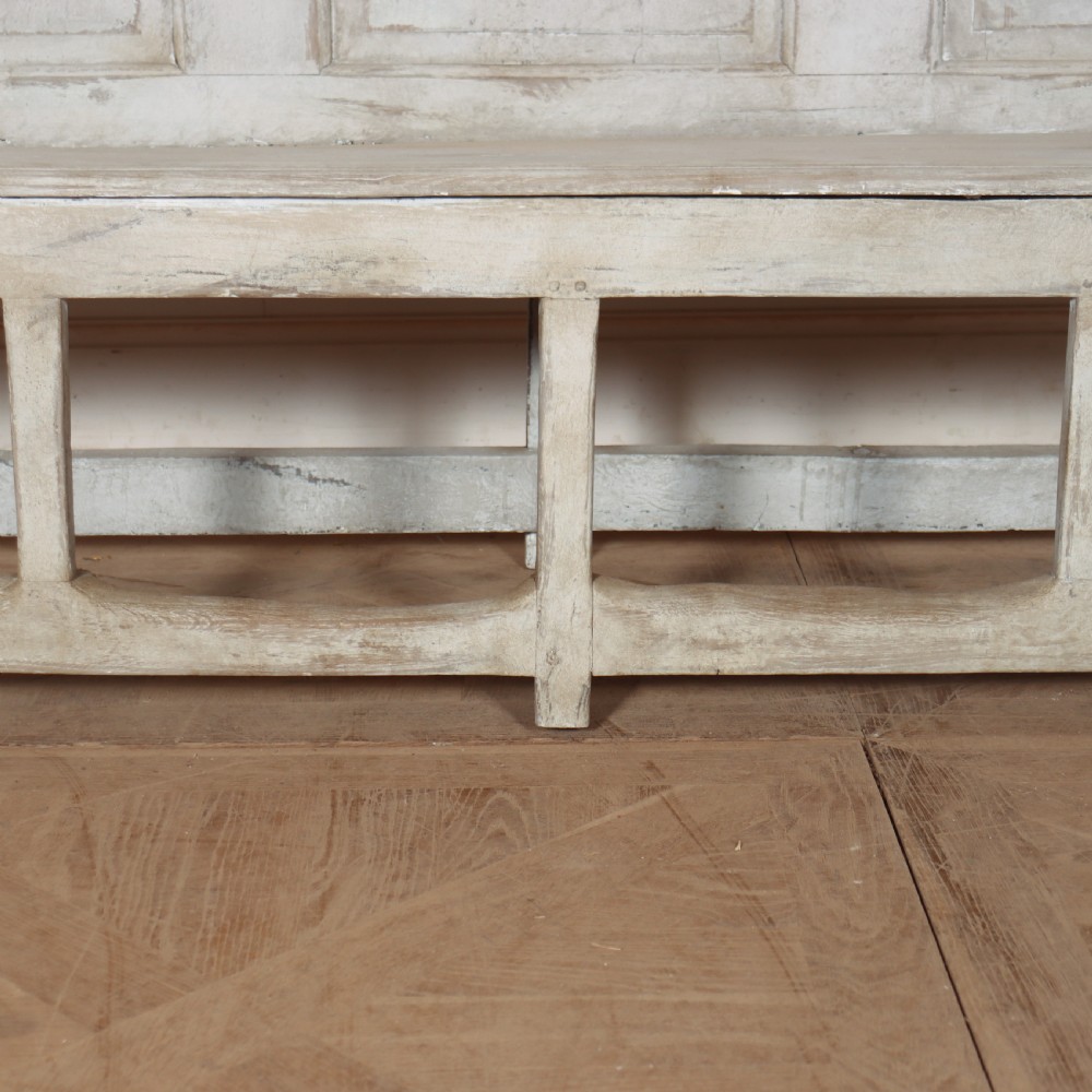 An 18th-century painted wooden tavern bench featuring a high back with three recessed panels, curved armrests, and lower stretchers. View V