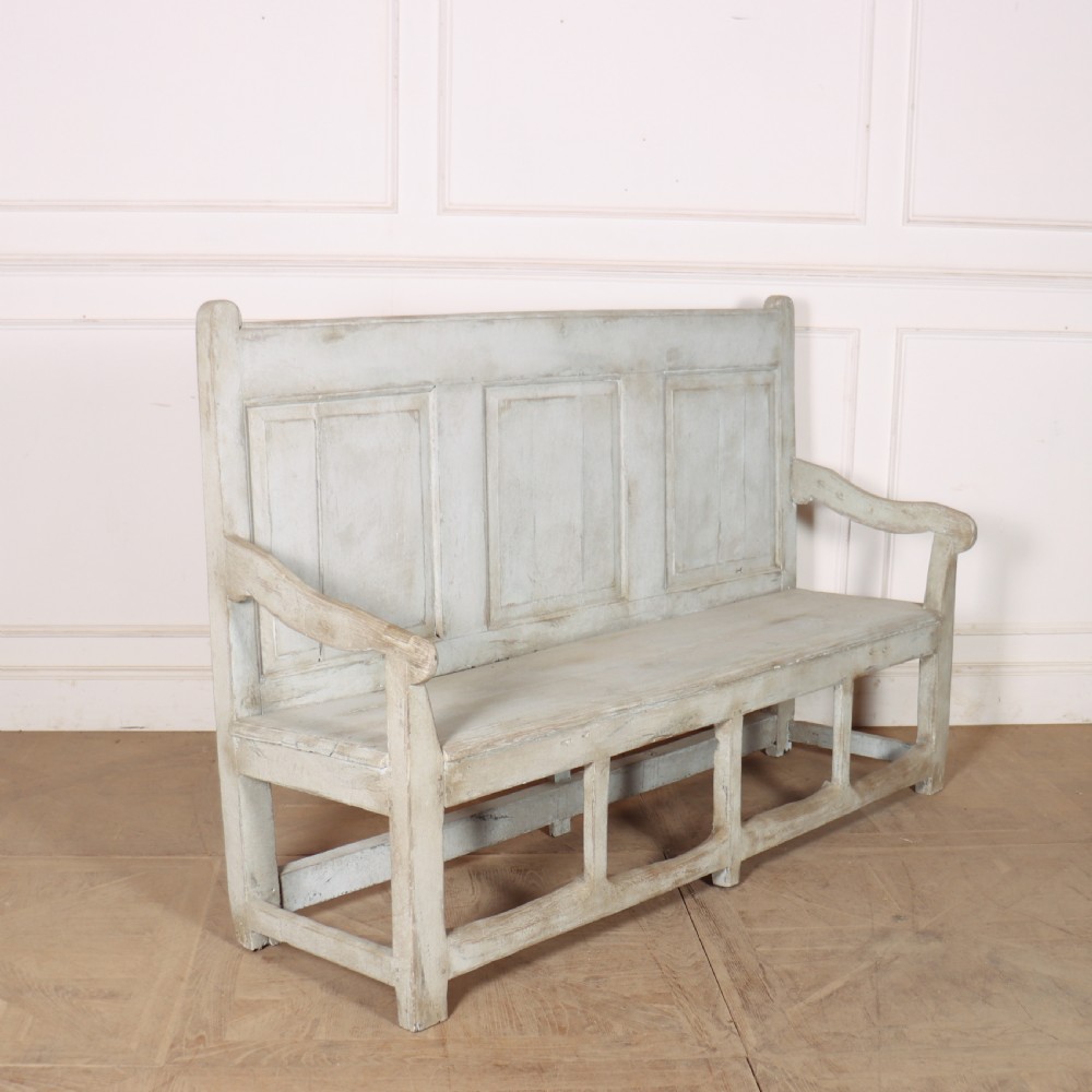 An 18th-century painted wooden tavern bench featuring a high back with three recessed panels, curved armrests, and lower stretchers. View VI