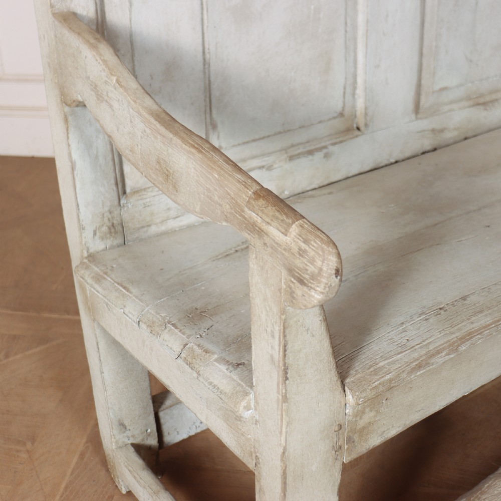 An 18th-century painted wooden tavern bench featuring a high back with three recessed panels, curved armrests, and lower stretchers. View VII