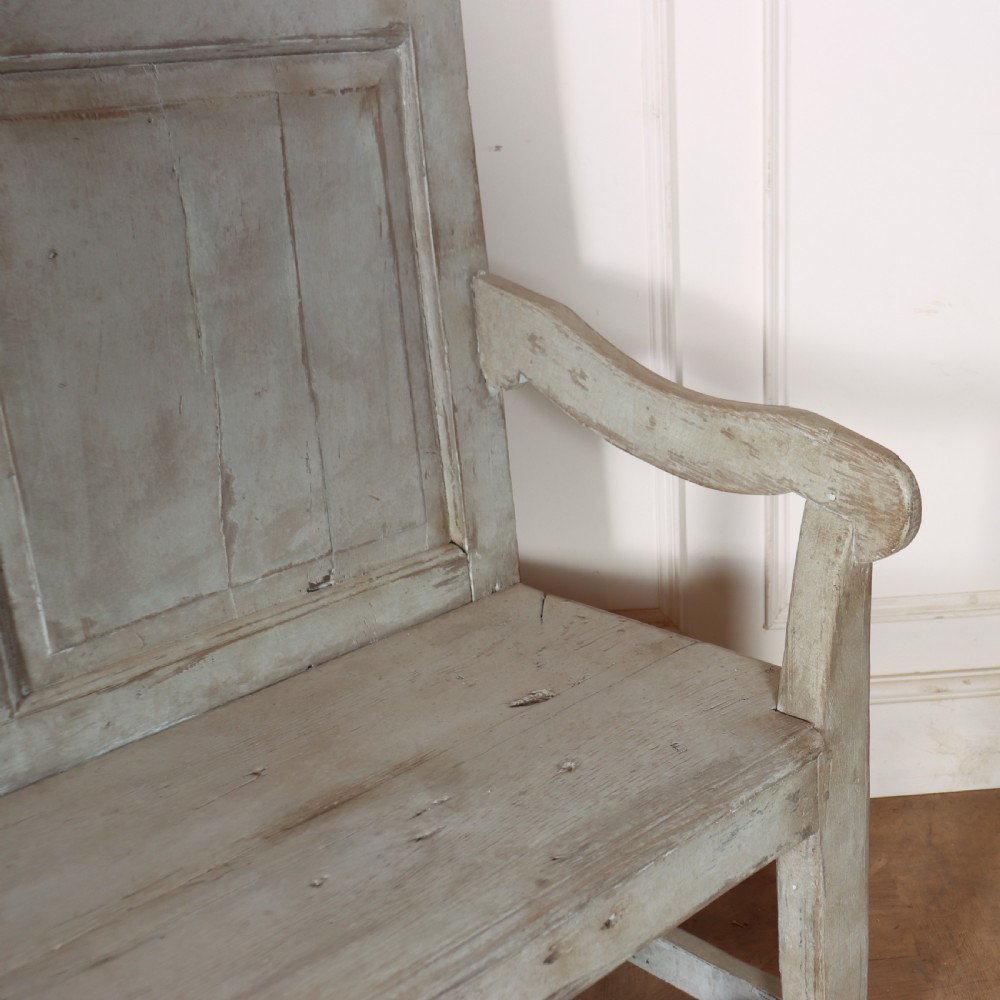 An 18th-century painted wooden tavern bench featuring a high back with three recessed panels, curved armrests, and lower stretchers. View VIII