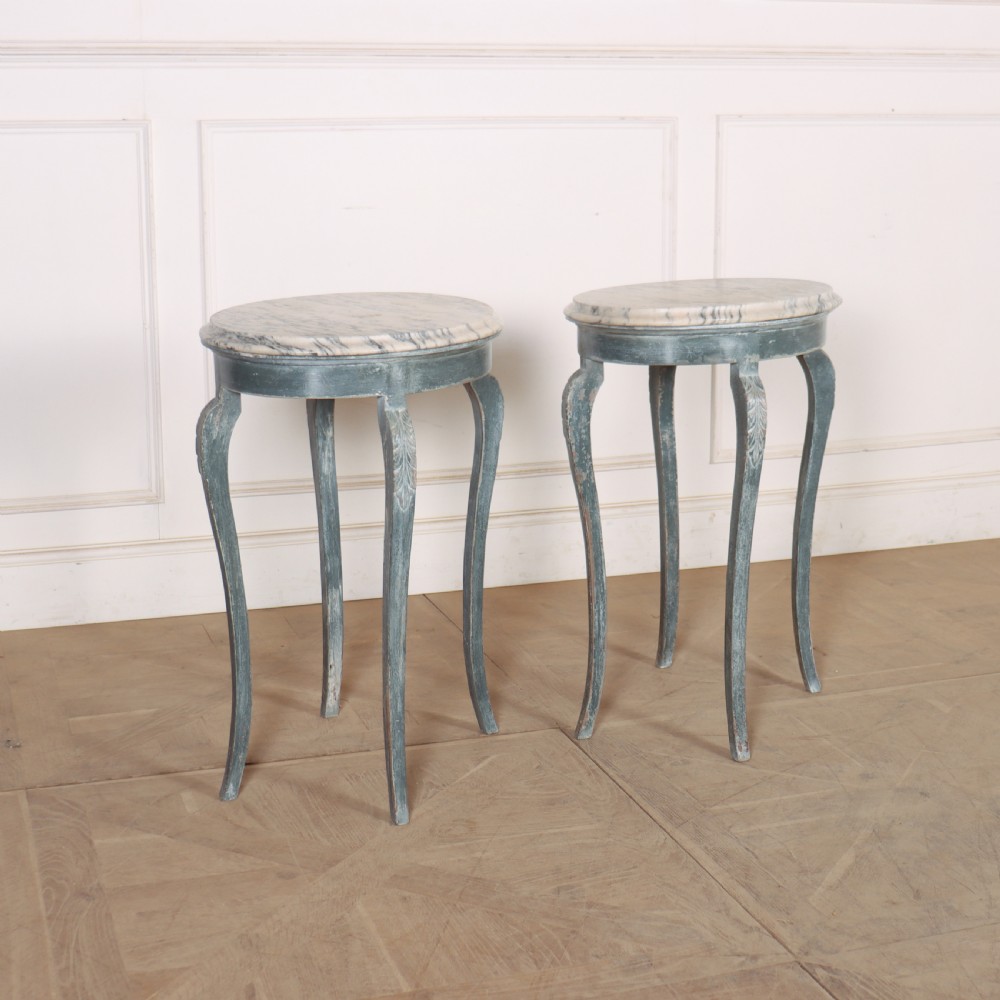 A pair of slim French painted wooden lamp tables featuring cabriole legs and oval marble tops.