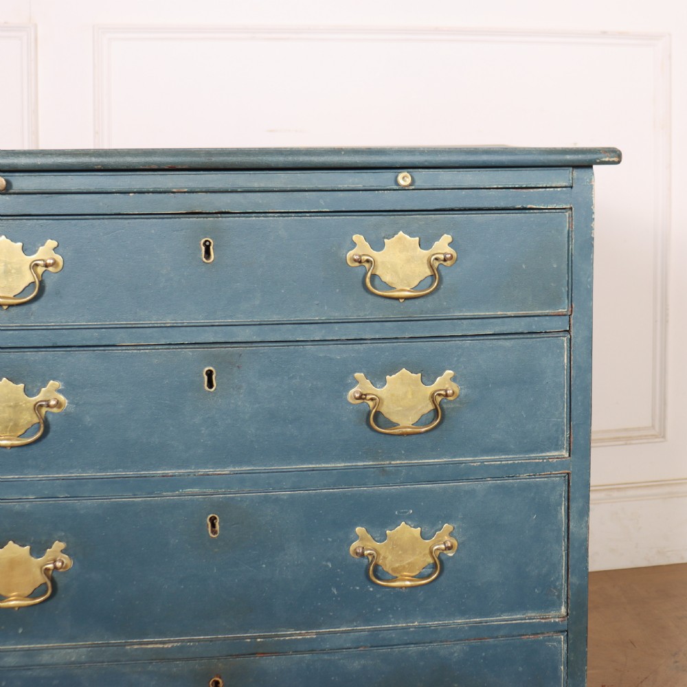 A four-drawer Georgian blue painted chest of drawers featuring brass swan-neck handles and bracket feet. View V