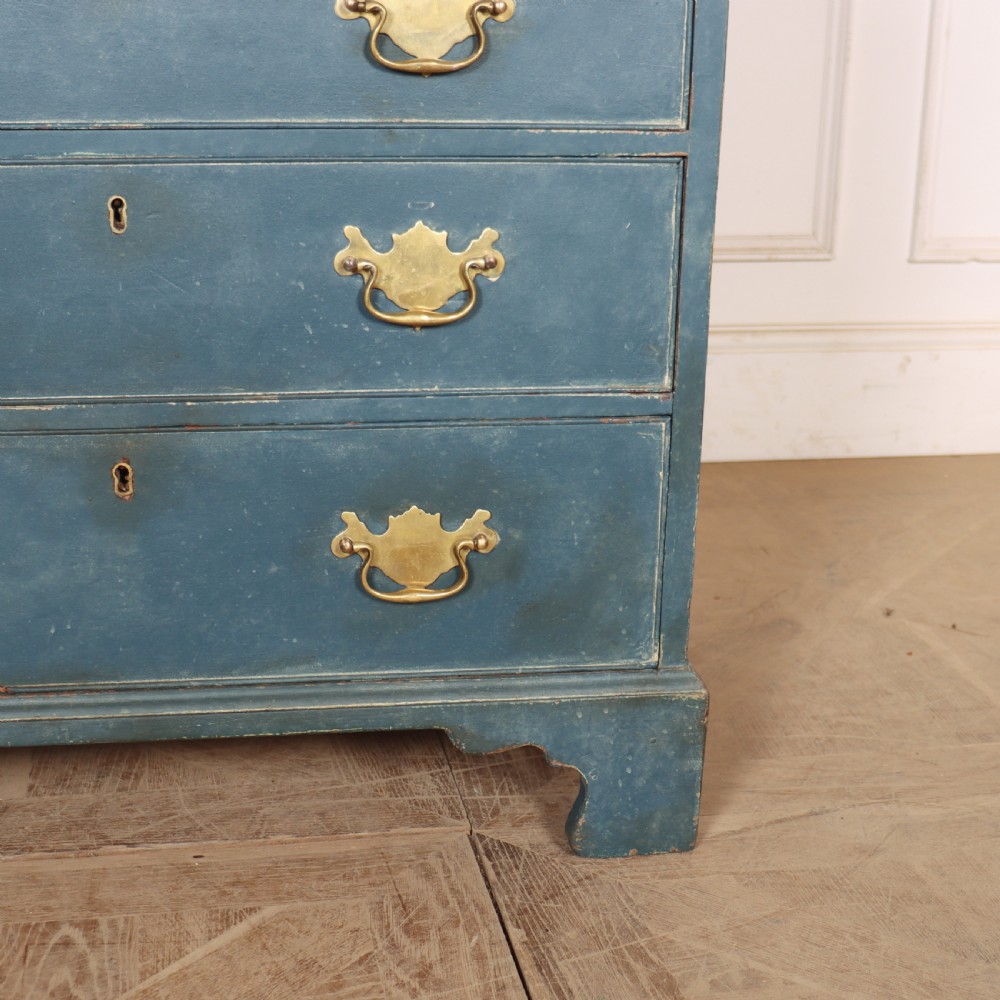 A four-drawer Georgian blue painted chest of drawers featuring brass swan-neck handles and bracket feet. View VI