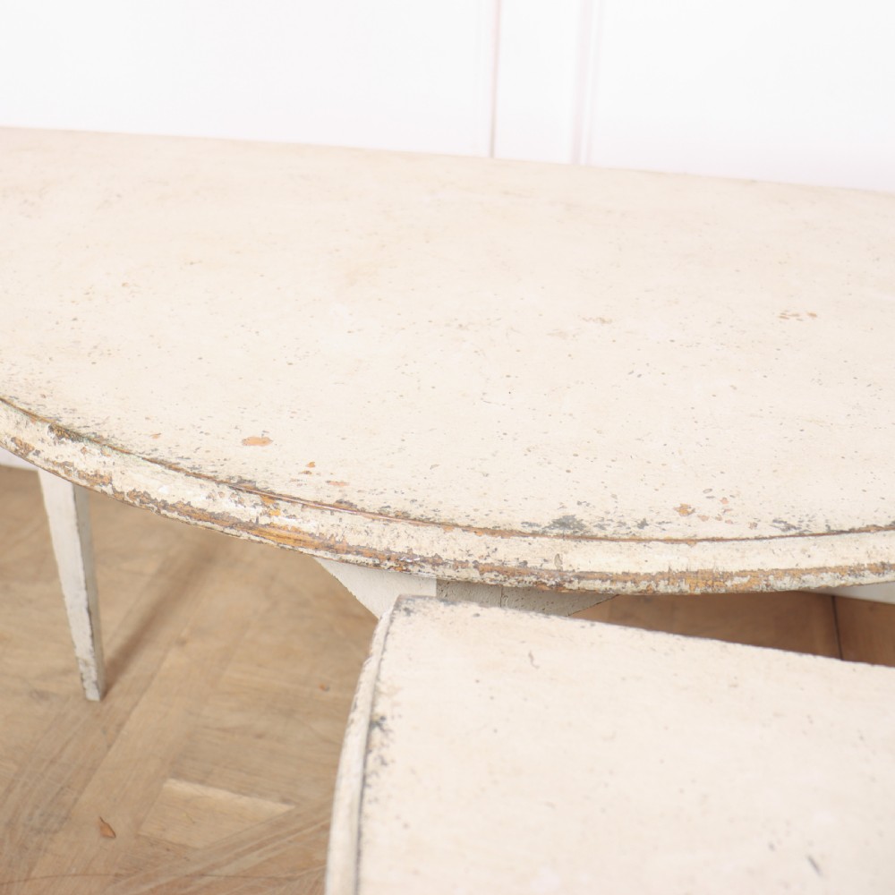 A pair of Swedish demi-lune console tables with distressed off-white painted finish and tapered legs. View VI