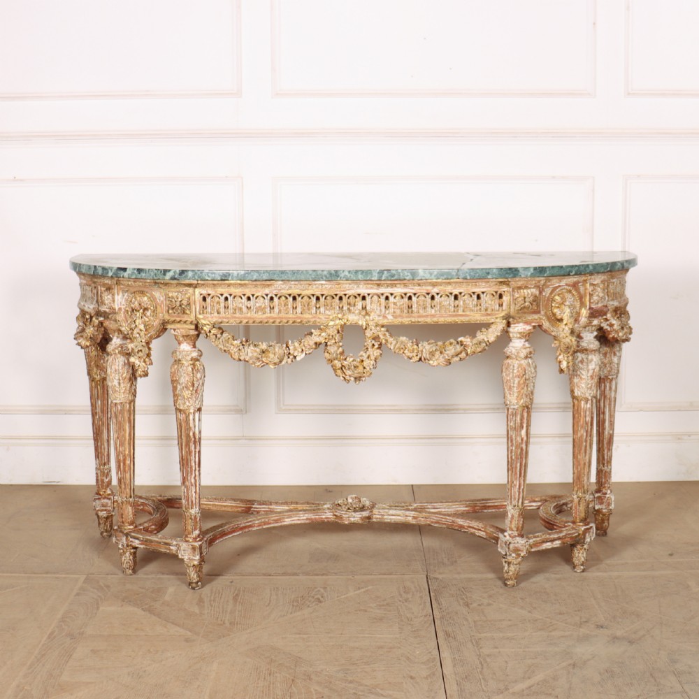 A 19th-century French demi-lune console table featuring a green marble top, ornate carved giltwood frieze with floral swags, and fluted legs. View II