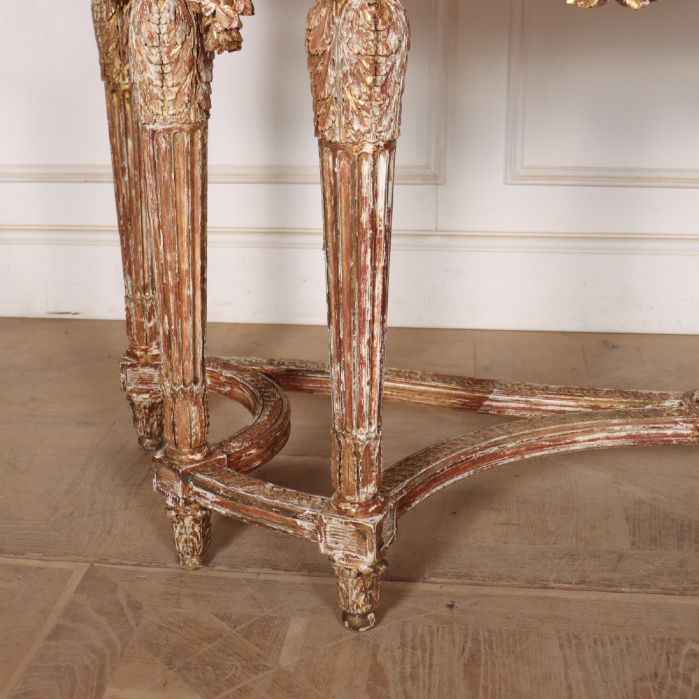 A 19th-century French demi-lune console table featuring a green marble top, ornate carved giltwood frieze with floral swags, and fluted legs. View IV