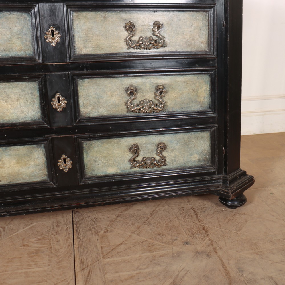 An 18th-century Italian three-drawer commode with a black painted frame, pale blue drawer panels, ornate brass handles, and bun feet. View II