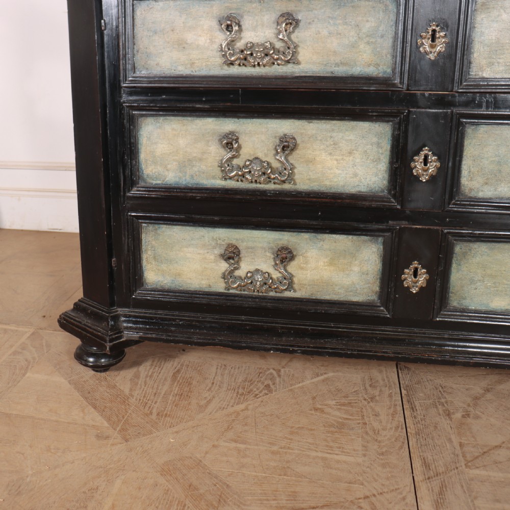 An 18th-century Italian three-drawer commode with a black painted frame, pale blue drawer panels, ornate brass handles, and bun feet. View VI