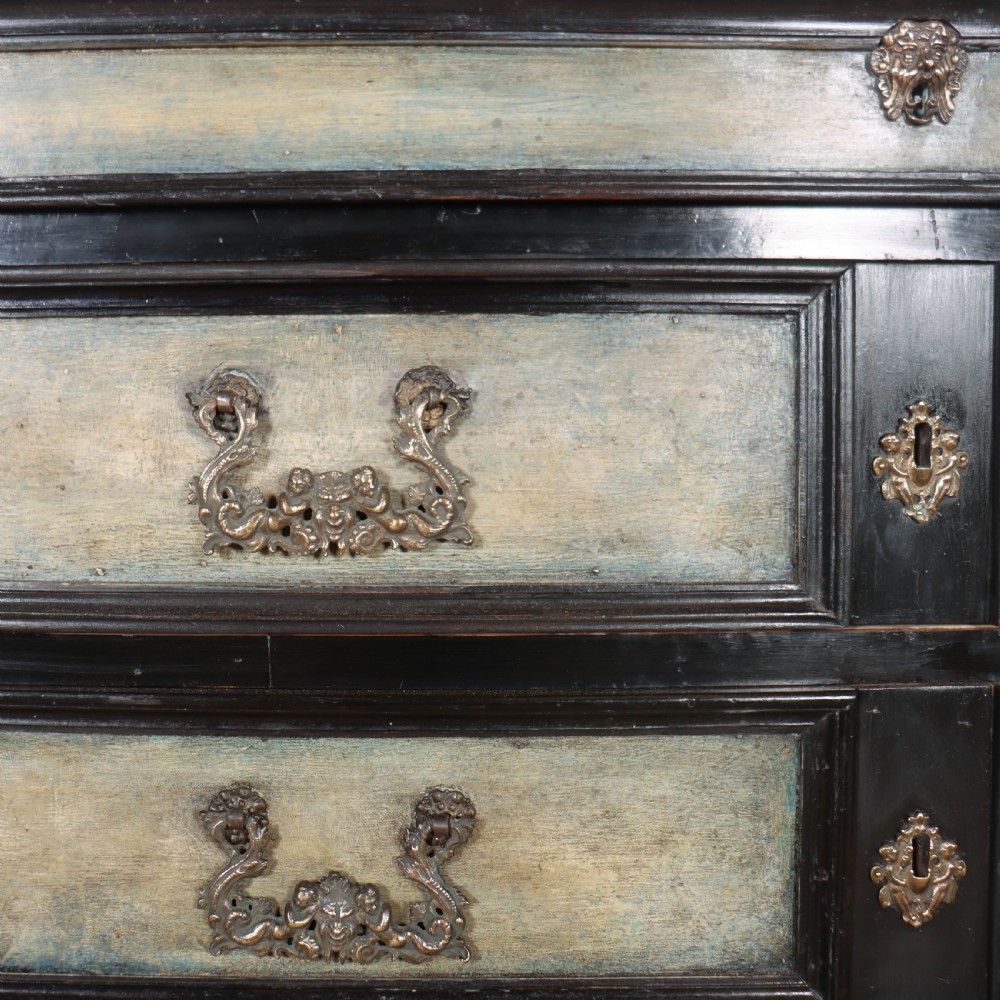 An 18th-century Italian three-drawer commode with a black painted frame, pale blue drawer panels, ornate brass handles, and bun feet. View VII