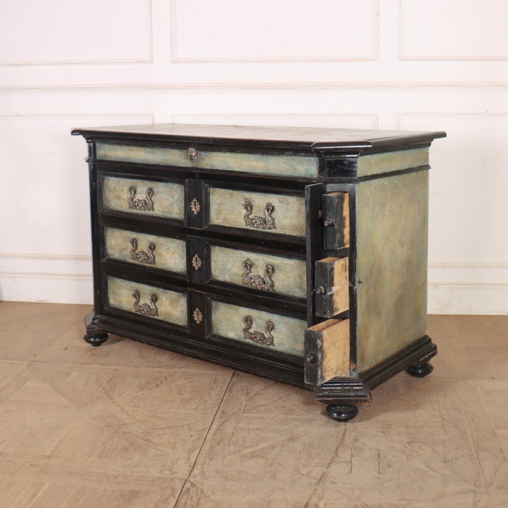 An 18th-century Italian three-drawer commode with a black painted frame, pale blue drawer panels, ornate brass handles, and bun feet. View IX