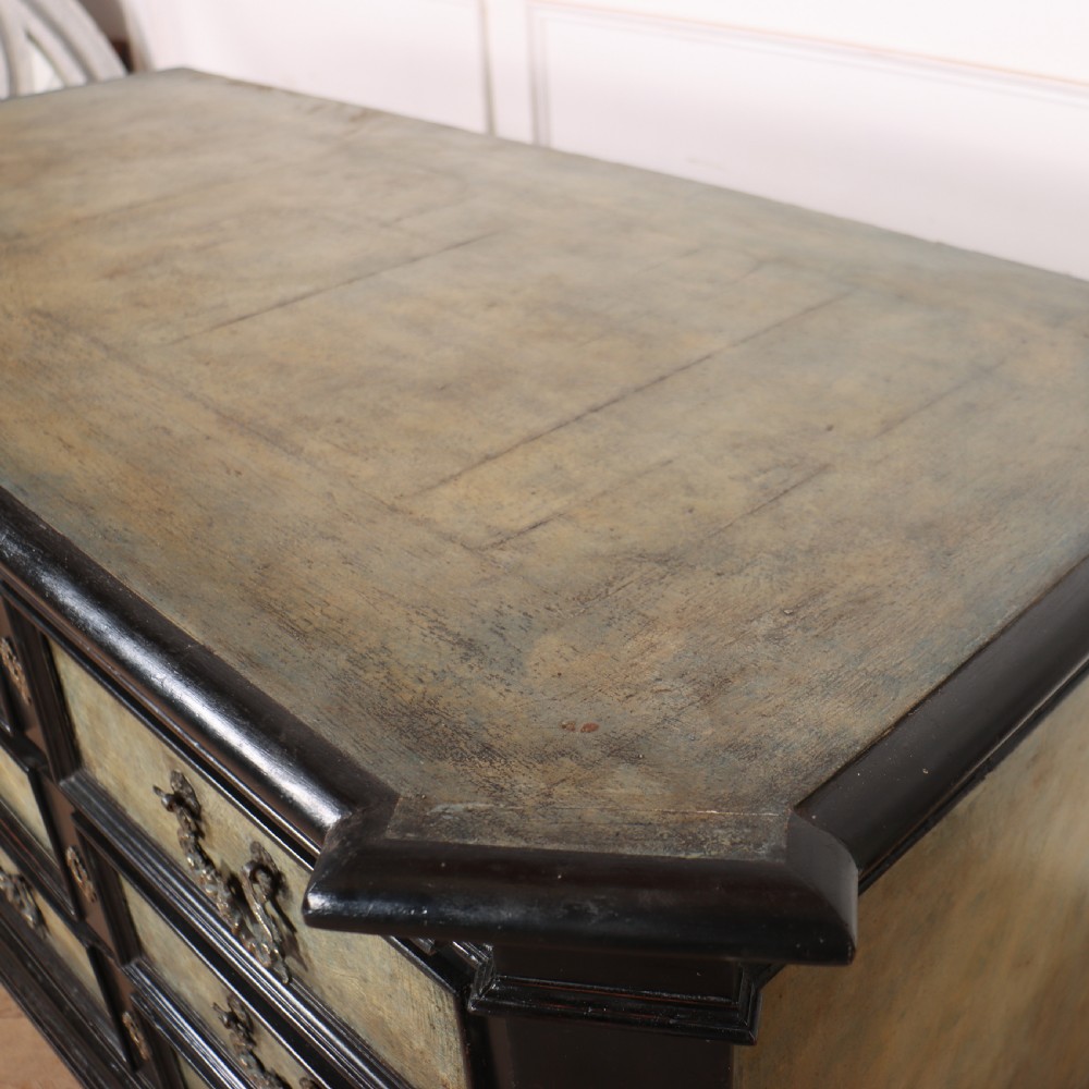 An 18th-century Italian three-drawer commode with a black painted frame, pale blue drawer panels, ornate brass handles, and bun feet. View XII