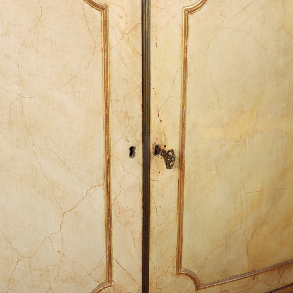 A Neoclassical style cream painted demi-lune side cabinet featuring a dark green marble top, fluted gilded frieze, and panelled cupboard doors. View VII