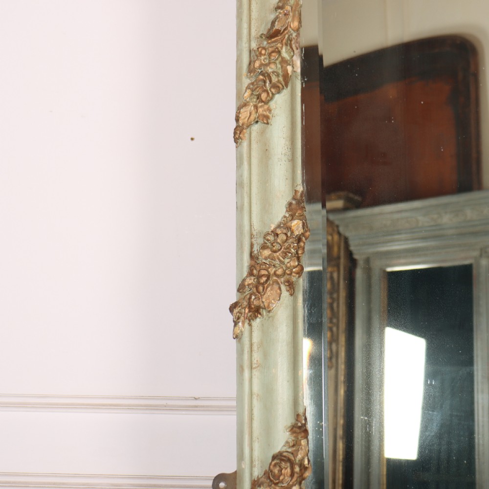 A tall French Rococo style mirror featuring an arched frame painted in pale grey-green with carved giltwood C-scrolls, lattice work, and foliate garlands. View VI