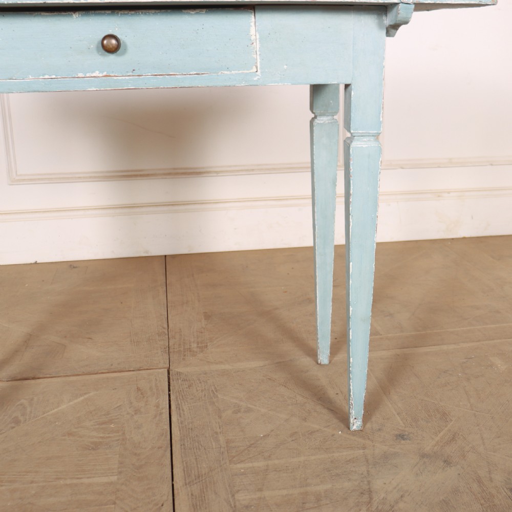 A rectangular light blue painted wooden lamp table featuring square tapered legs and a single drawer with a round brass knob. View IV