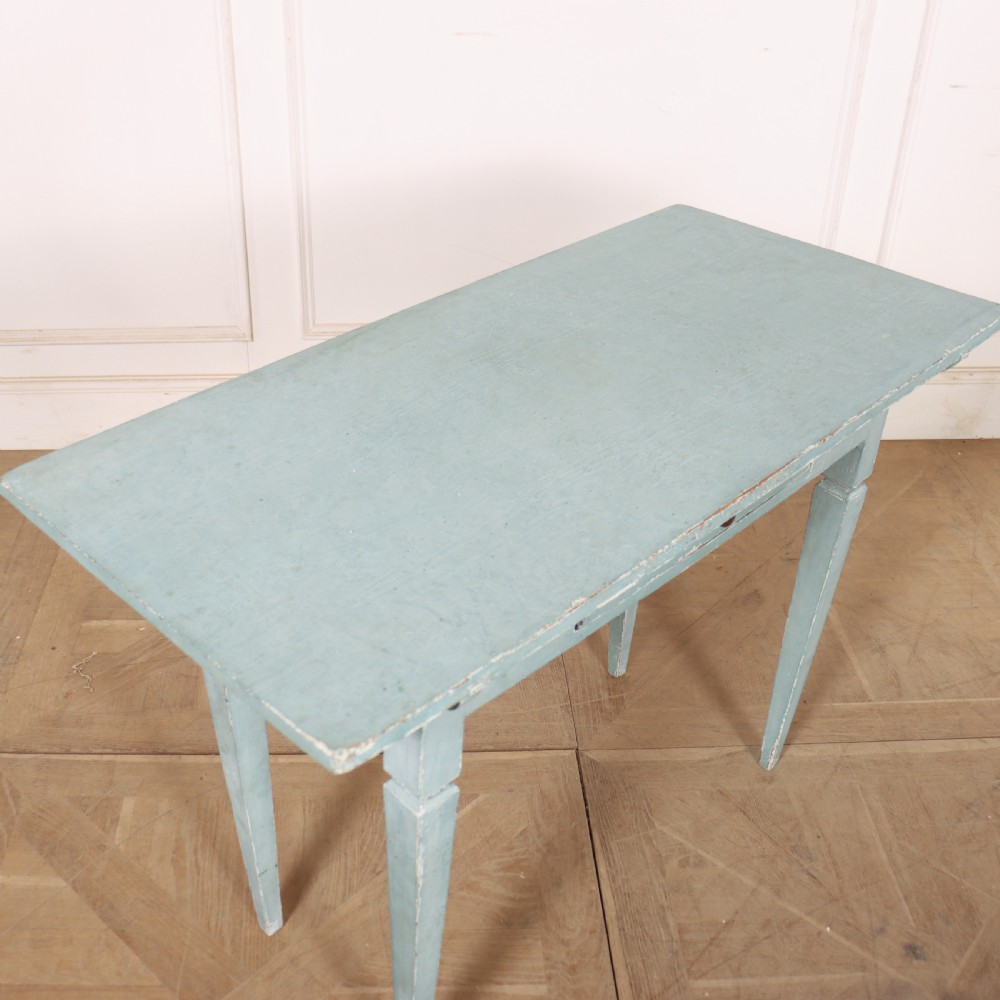 A rectangular light blue painted wooden lamp table featuring square tapered legs and a single drawer with a round brass knob. View VI