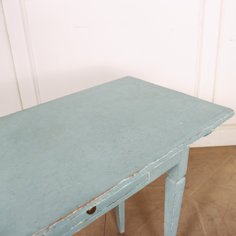 A rectangular light blue painted wooden lamp table featuring square tapered legs and a single drawer with a round brass knob. View VIII