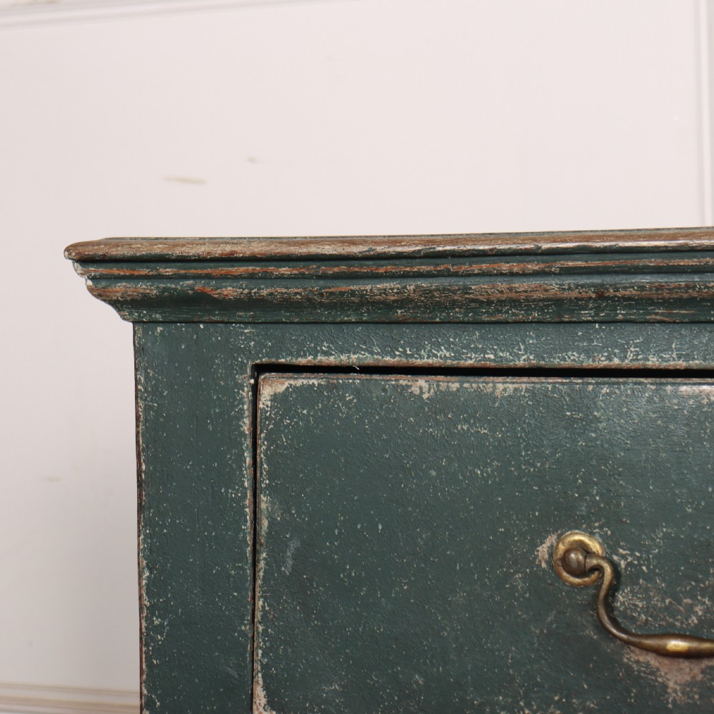 An English wooden dresser base painted in distressed muted green with three drawers and brass swan-neck handles. View VII