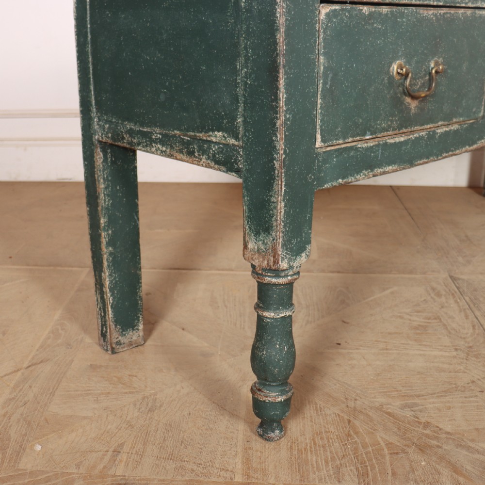 An English wooden dresser base painted in distressed muted green with three drawers and brass swan-neck handles. View X