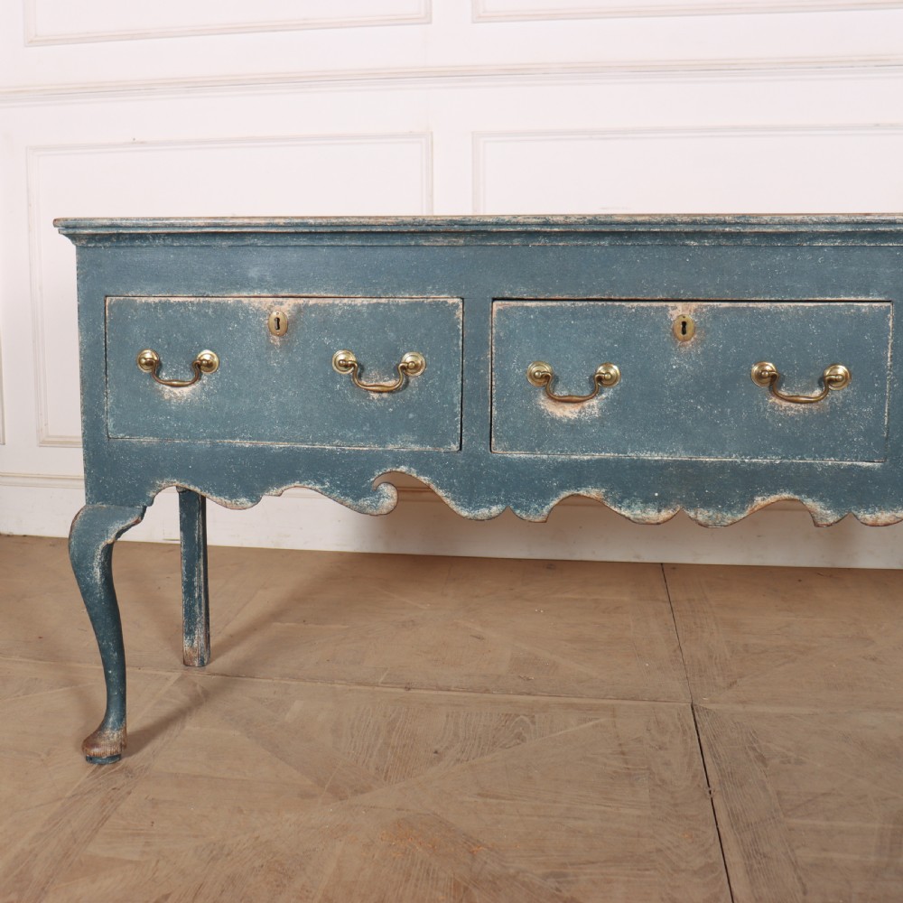 An antique blue-painted dresser base featuring three drawers with brass drop handles, a scalloped apron, and cabriole legs. View II