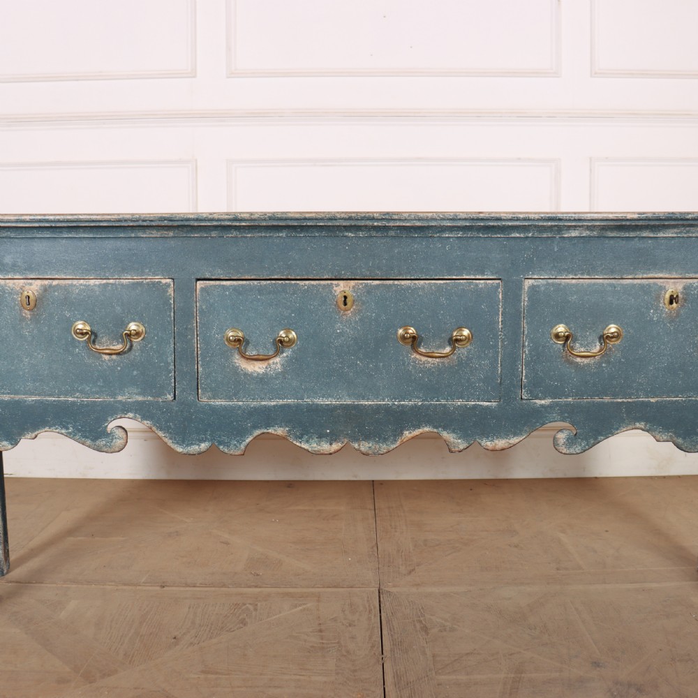 An antique blue-painted dresser base featuring three drawers with brass drop handles, a scalloped apron, and cabriole legs. View IV