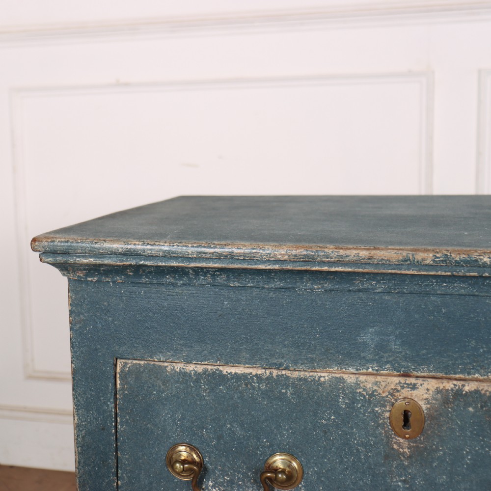 An antique blue-painted dresser base featuring three drawers with brass drop handles, a scalloped apron, and cabriole legs. View V