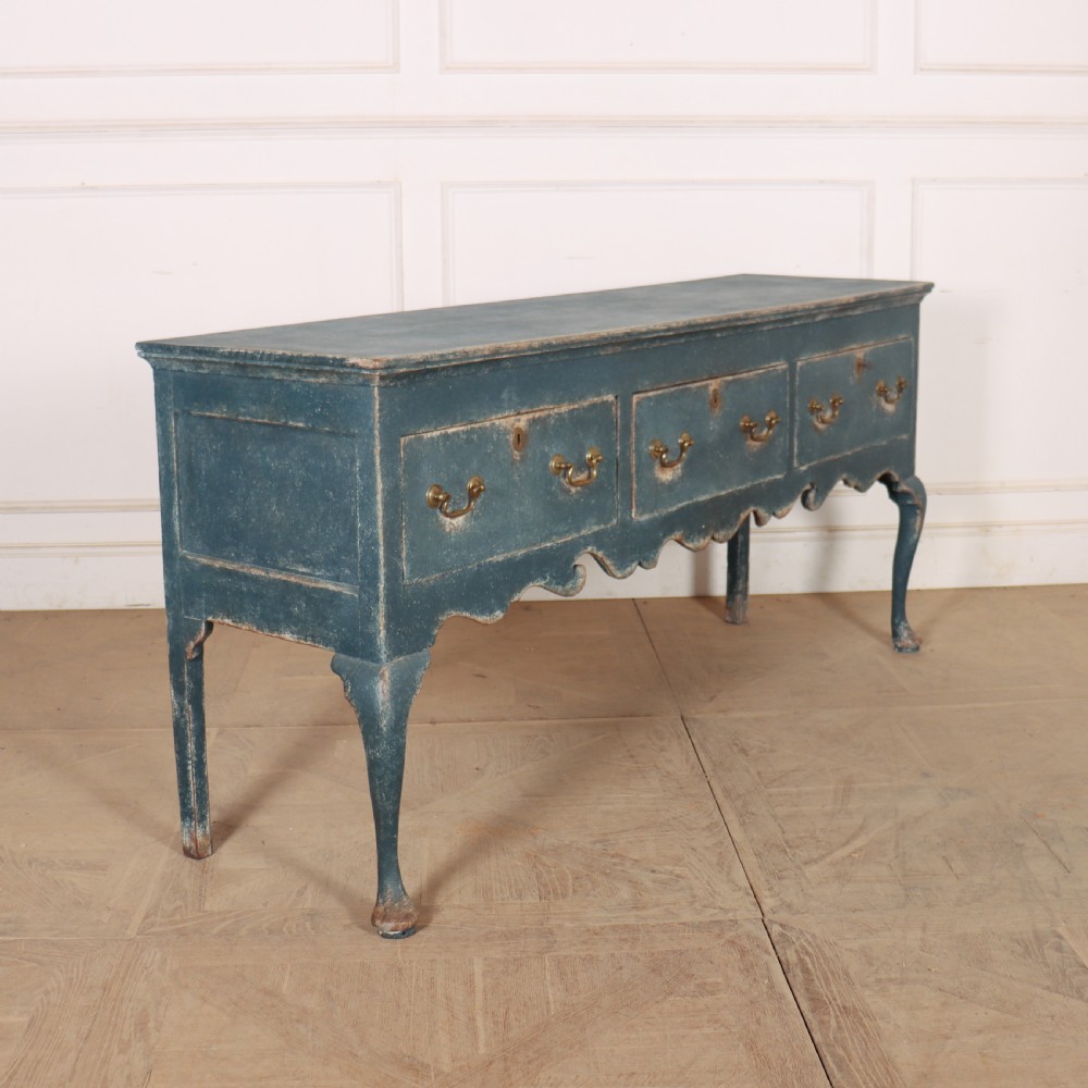 An antique blue-painted dresser base featuring three drawers with brass drop handles, a scalloped apron, and cabriole legs. View VIII