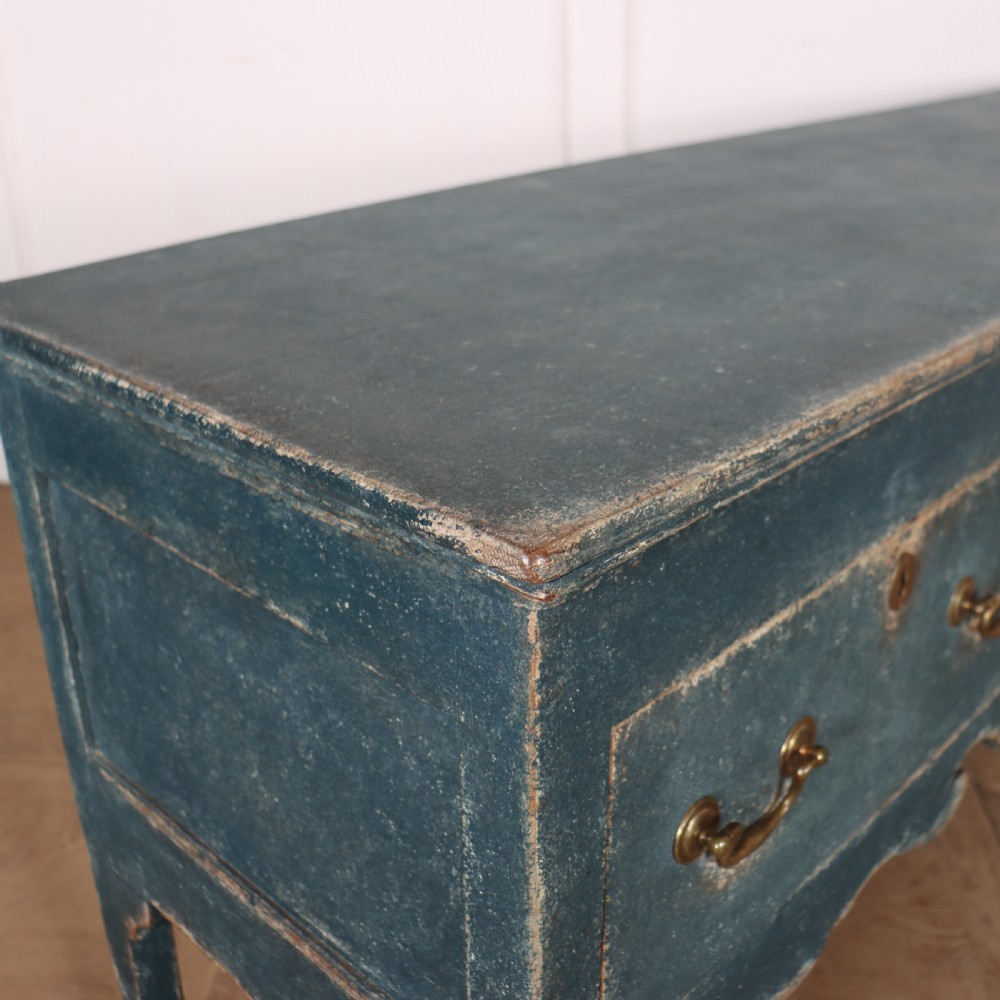An antique blue-painted dresser base featuring three drawers with brass drop handles, a scalloped apron, and cabriole legs. View X