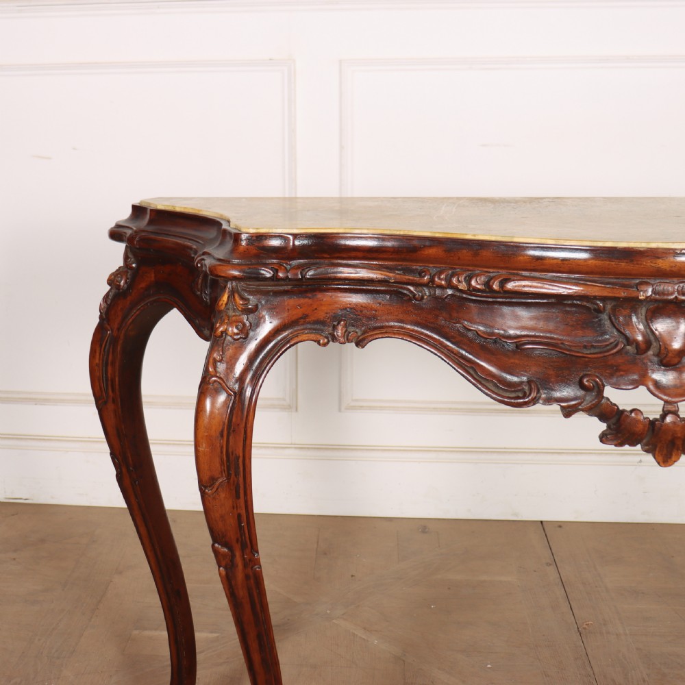 An antique 1920s Italian console table featuring a serpentine front, carved apron with scroll detailing, cabriole legs, and a marble top. View II