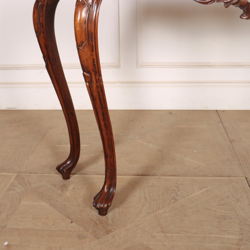 An antique 1920s Italian console table featuring a serpentine front, carved apron with scroll detailing, cabriole legs, and a marble top. View III