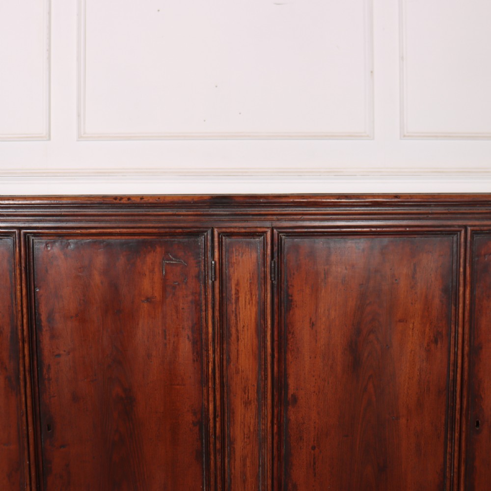 A large antique Italian dark walnut sideboard featuring four moulded rectangular panel doors and a solid plinth base. View III