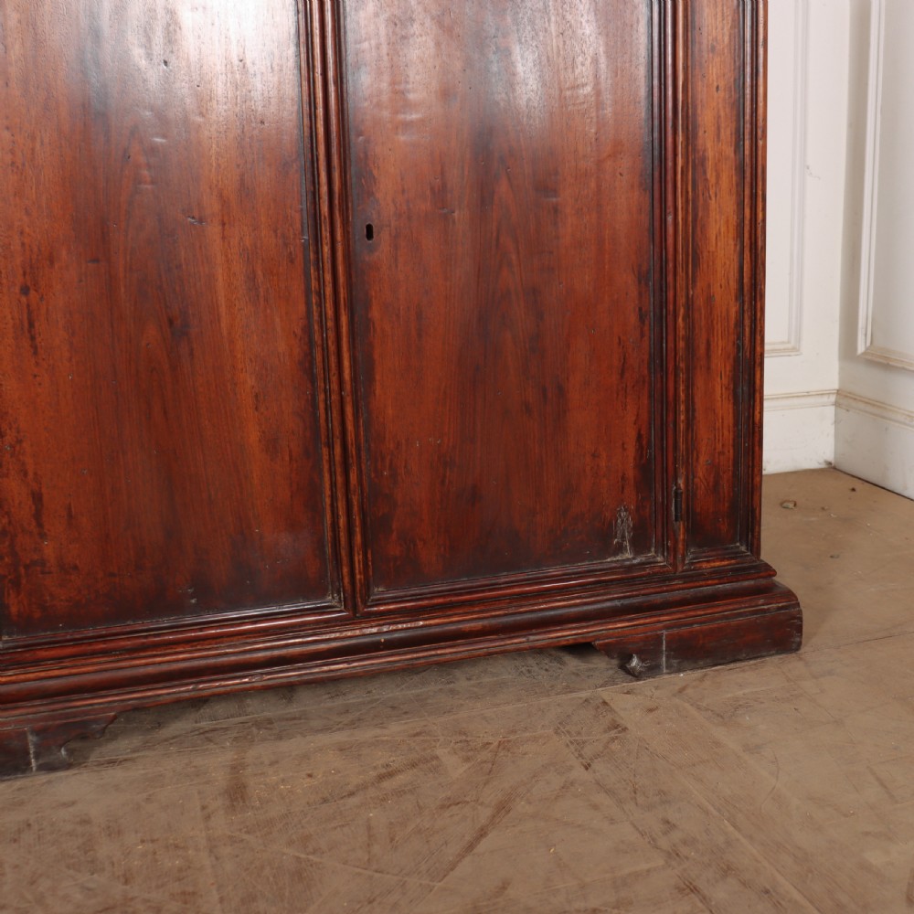 A large antique Italian dark walnut sideboard featuring four moulded rectangular panel doors and a solid plinth base. View VI