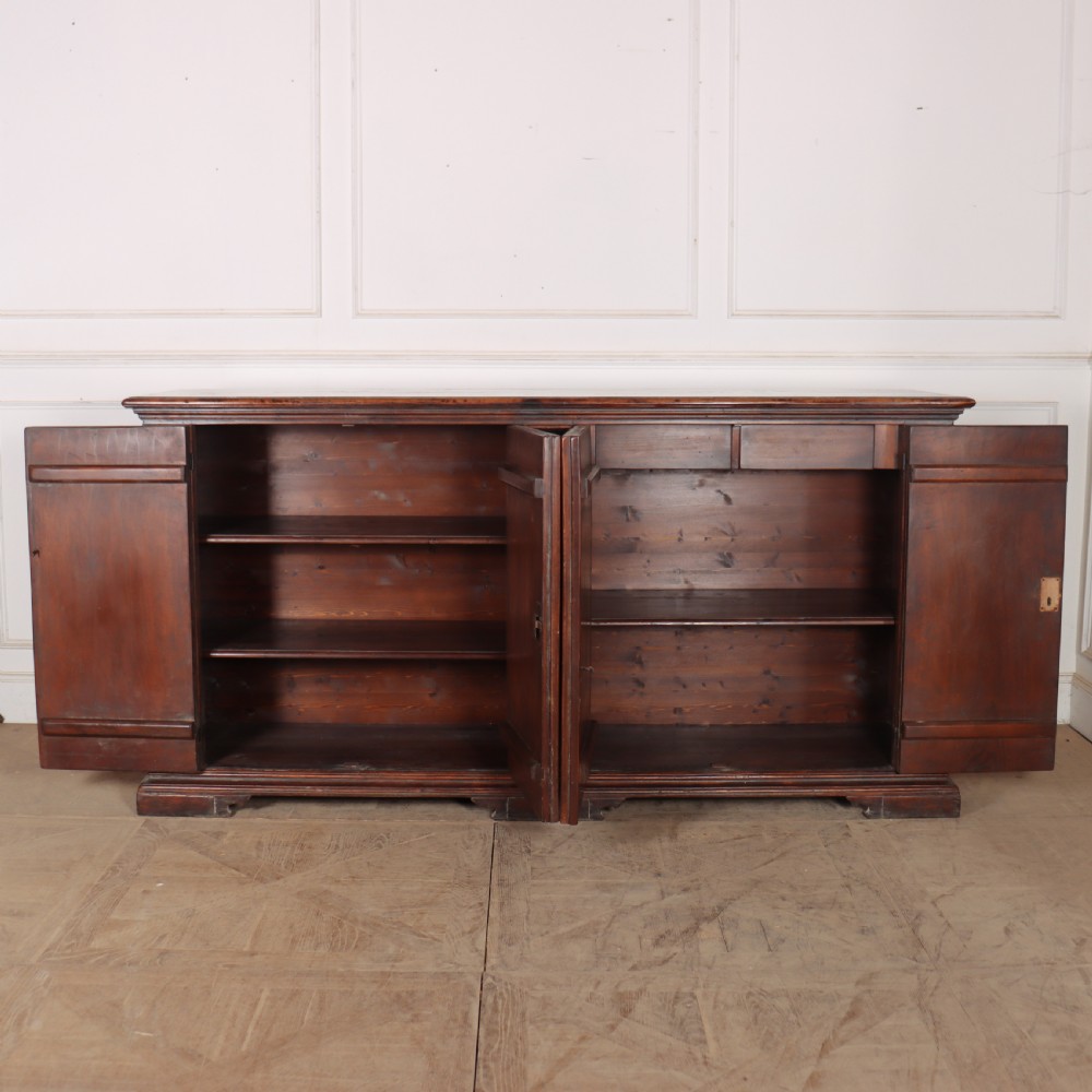 A large antique Italian dark walnut sideboard featuring four moulded rectangular panel doors and a solid plinth base. View VIII
