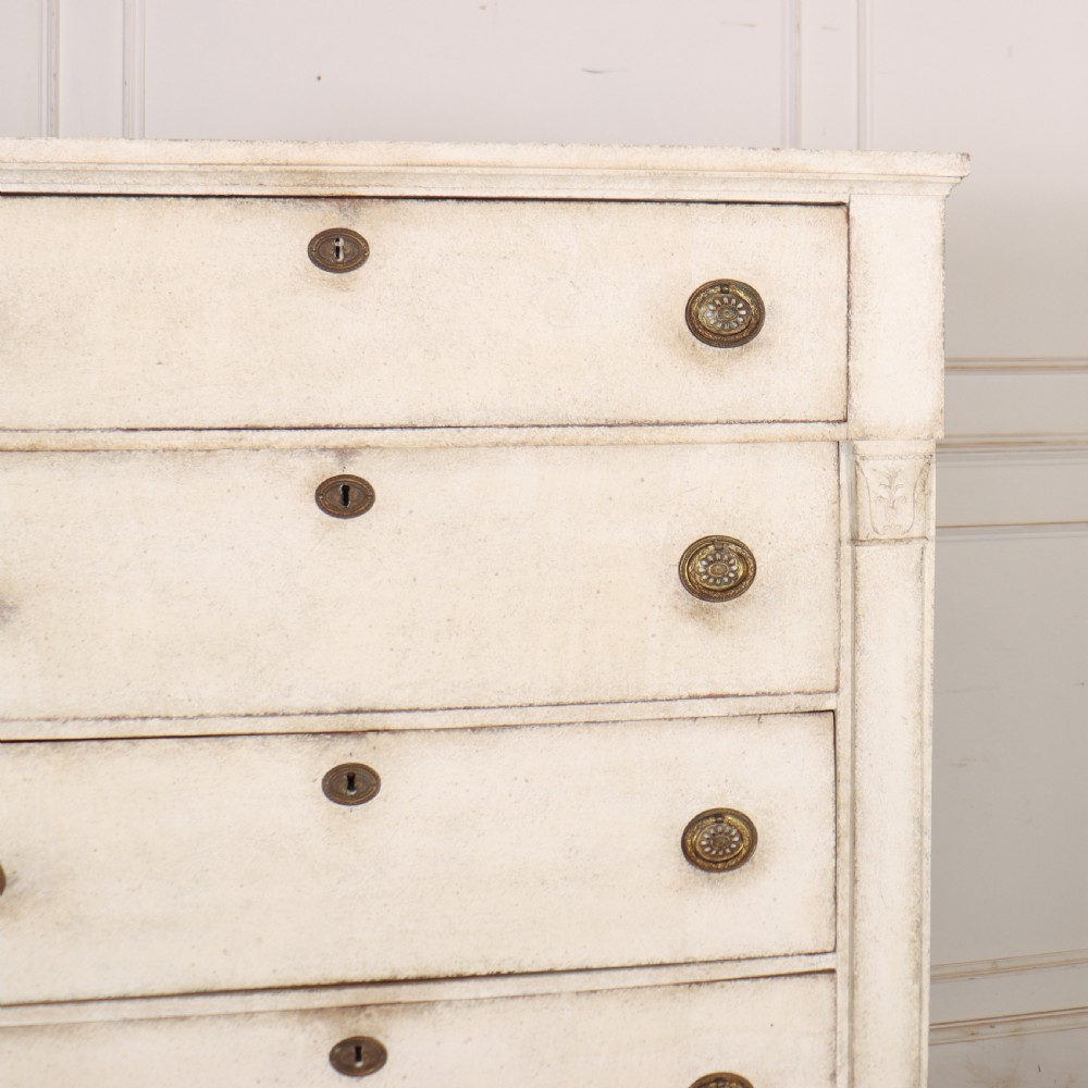 An off-white painted tallboy chest of drawers featuring six stacked drawers with round brass handles and keyhole escutcheons. View II