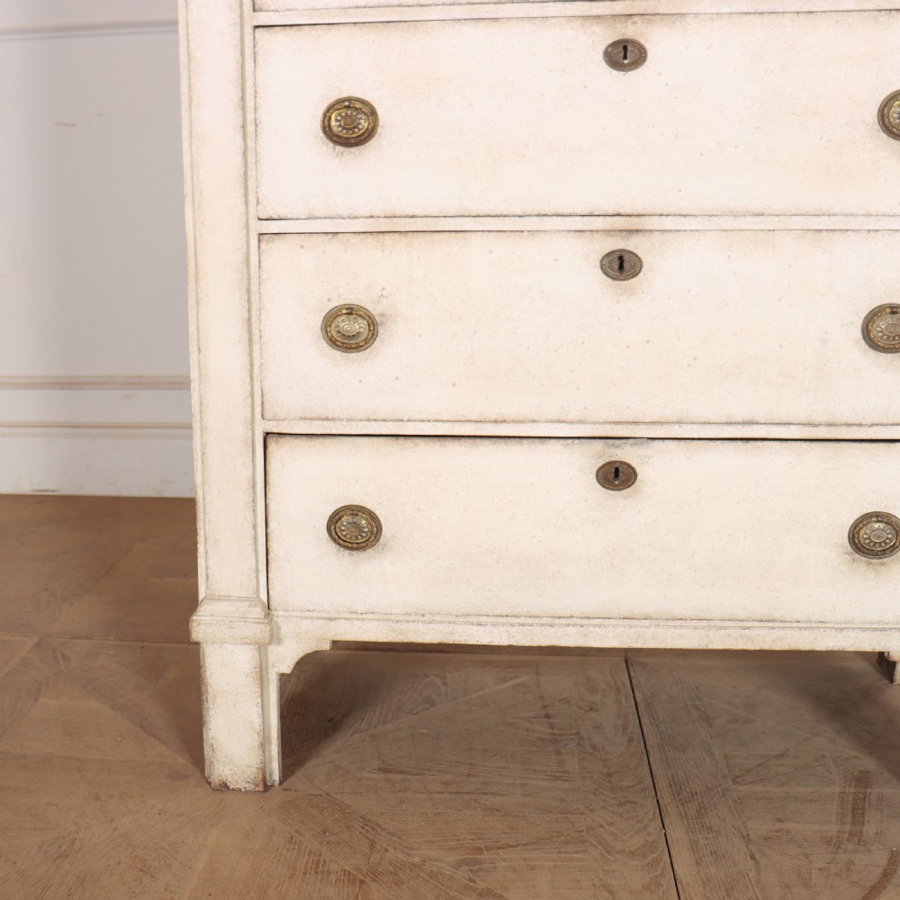 An off-white painted tallboy chest of drawers featuring six stacked drawers with round brass handles and keyhole escutcheons. View III
