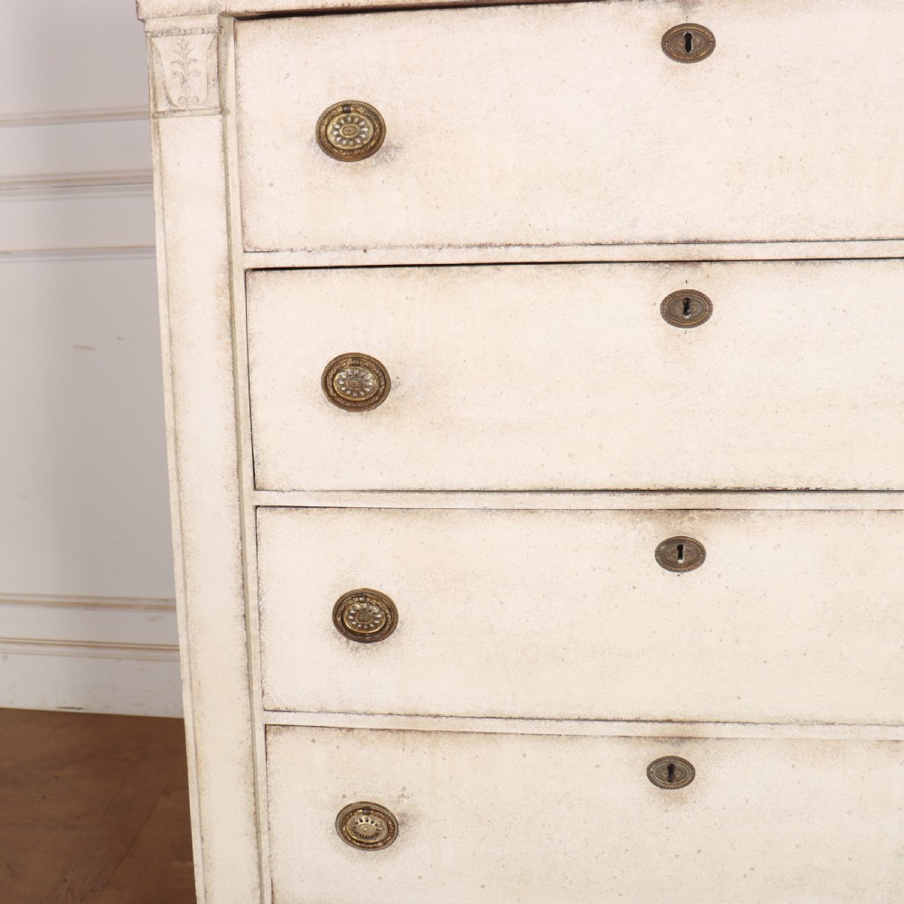 An off-white painted tallboy chest of drawers featuring six stacked drawers with round brass handles and keyhole escutcheons. View VIII