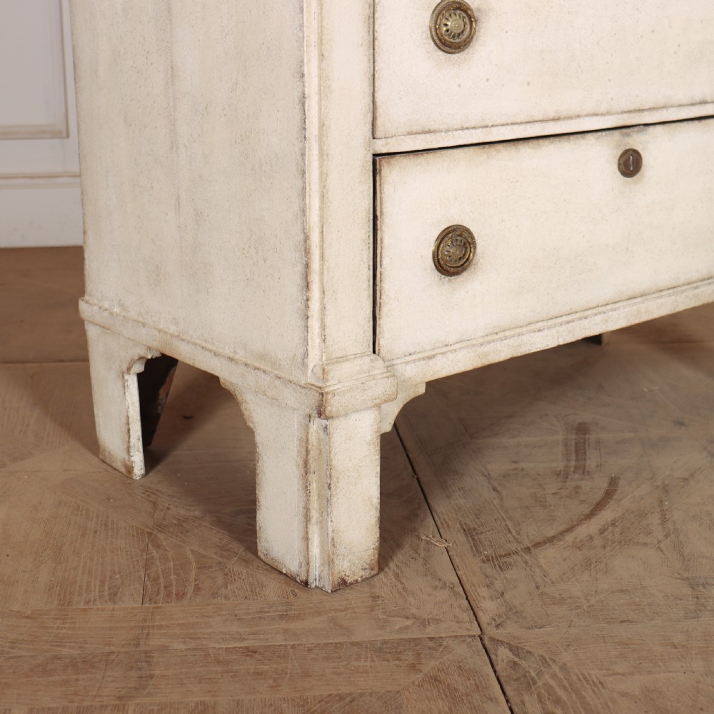 An off-white painted tallboy chest of drawers featuring six stacked drawers with round brass handles and keyhole escutcheons. View XI