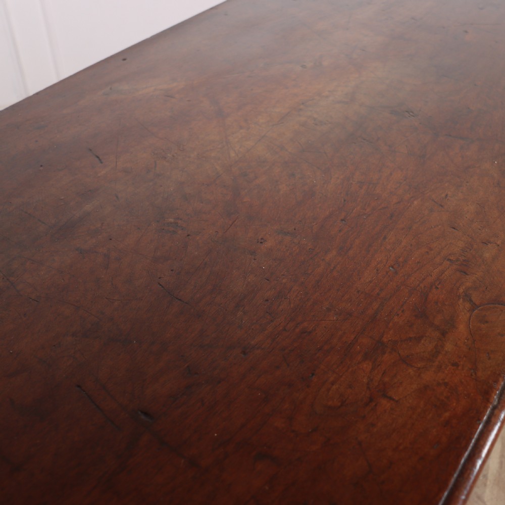 A long, monumental dark walnut Italian credenza featuring geometric moulded panel doors, a central column of drawers, and carved plinth feet. View XIV