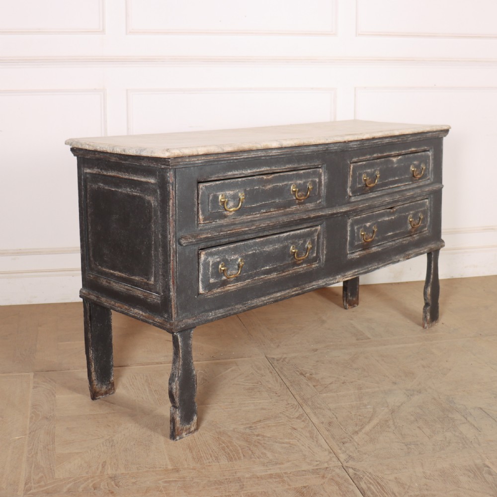 An English painted dresser base featuring a dark charcoal finish, four wide drawers with brass drop handles, shaped corner legs, and a light marble top. View XI