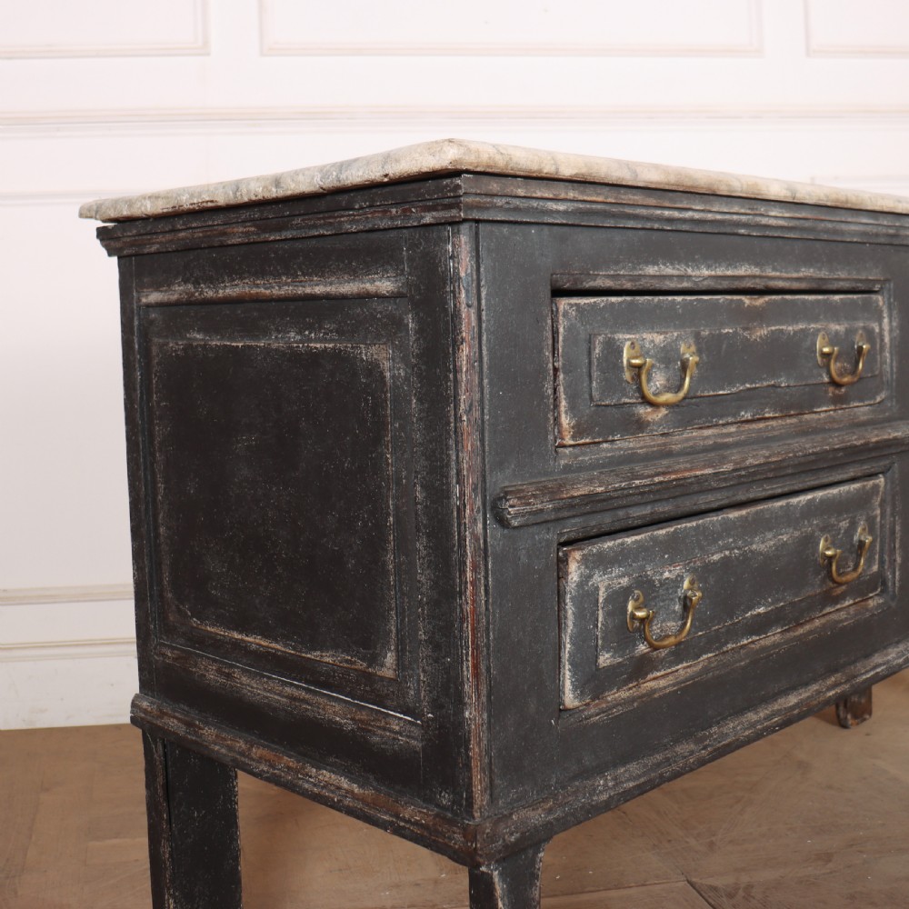 An English painted dresser base featuring a dark charcoal finish, four wide drawers with brass drop handles, shaped corner legs, and a light marble top. View XII