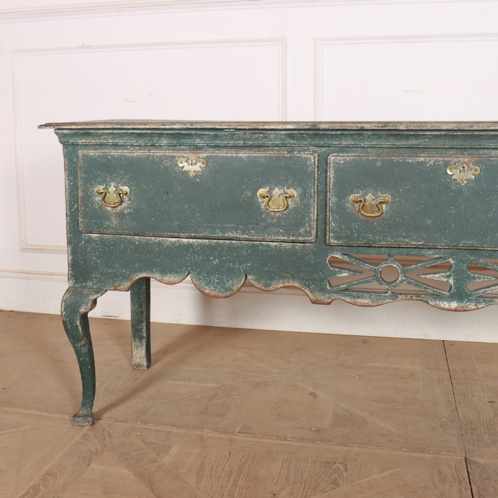 A long antique green painted dresser base featuring three drawers with brass handles, a scalloped apron with pierced fretwork, and cabriole legs. View II