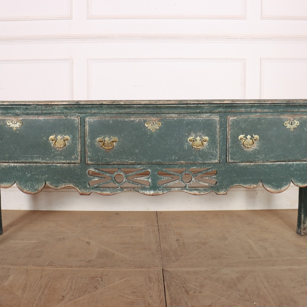 A long antique green painted dresser base featuring three drawers with brass handles, a scalloped apron with pierced fretwork, and cabriole legs. View III
