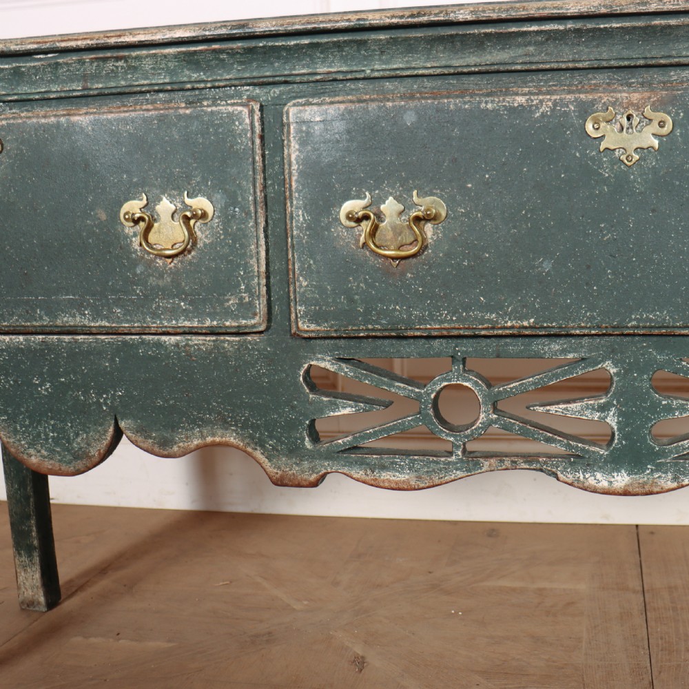 A long antique green painted dresser base featuring three drawers with brass handles, a scalloped apron with pierced fretwork, and cabriole legs. View V