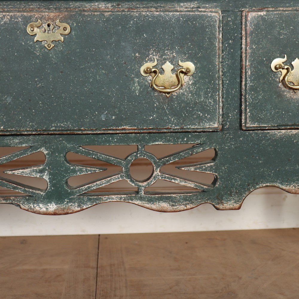 A long antique green painted dresser base featuring three drawers with brass handles, a scalloped apron with pierced fretwork, and cabriole legs. View VI