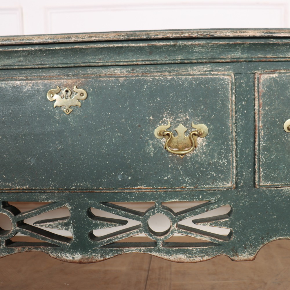 A long antique green painted dresser base featuring three drawers with brass handles, a scalloped apron with pierced fretwork, and cabriole legs. View IX
