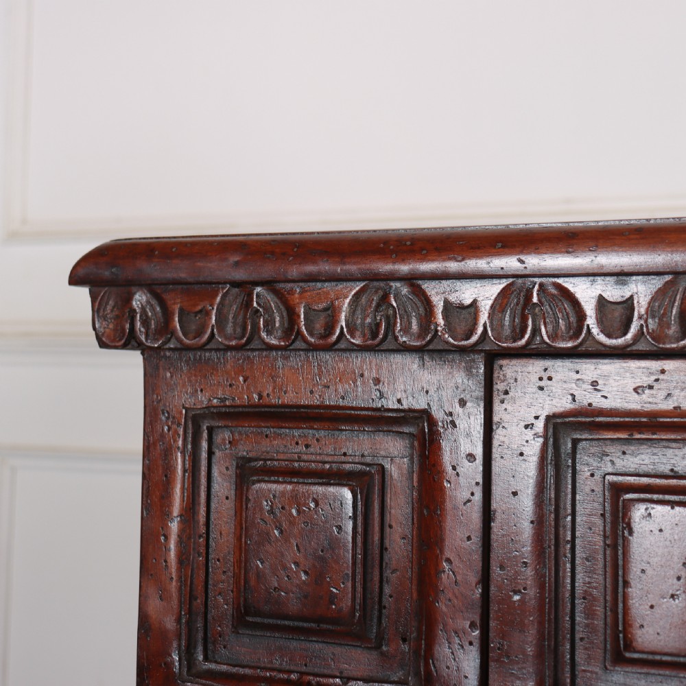 An antique dark walnut Italian sideboard featuring three upper frieze drawers and three carved panelled doors. View IX