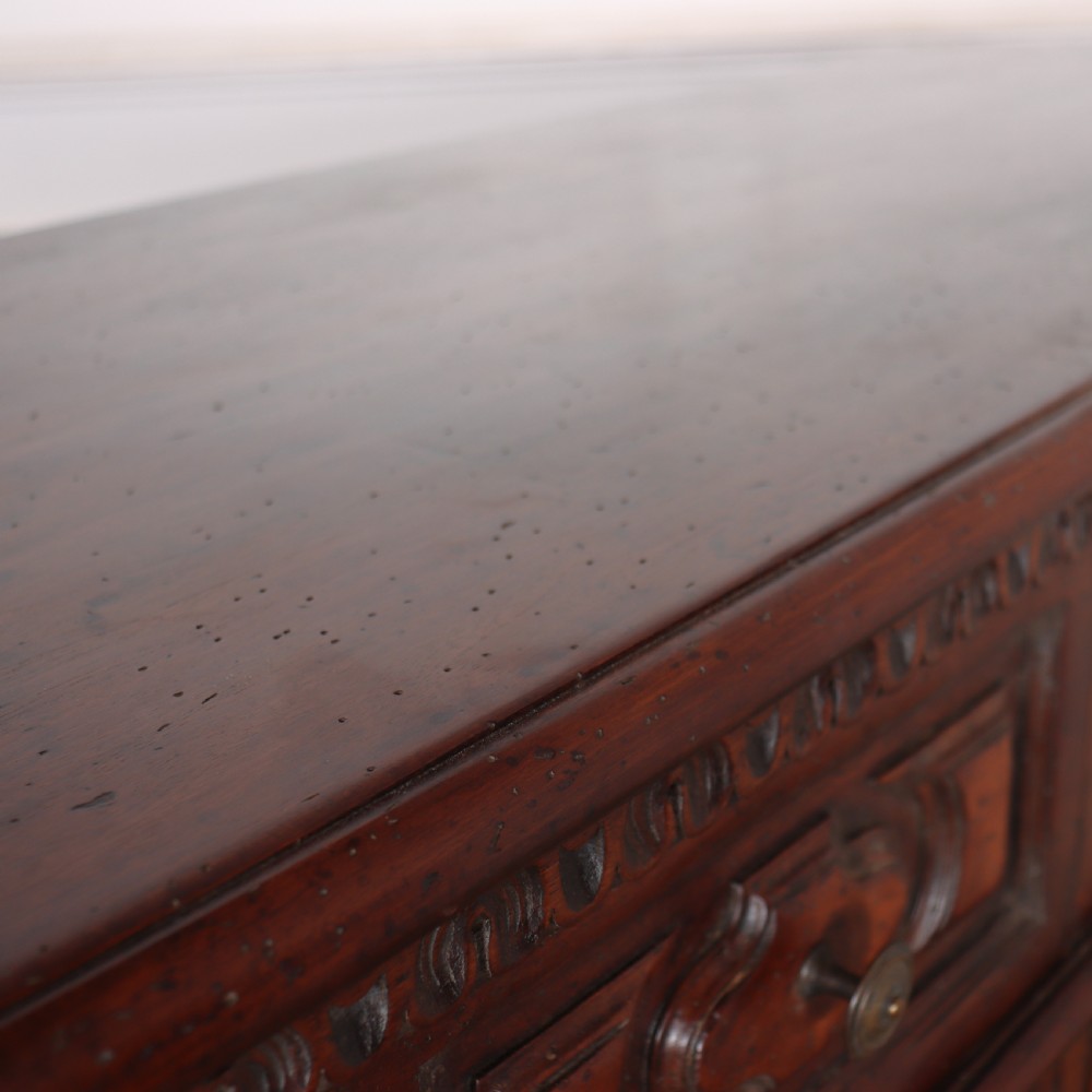 An antique dark walnut Italian sideboard featuring three upper frieze drawers and three carved panelled doors. View XVI
