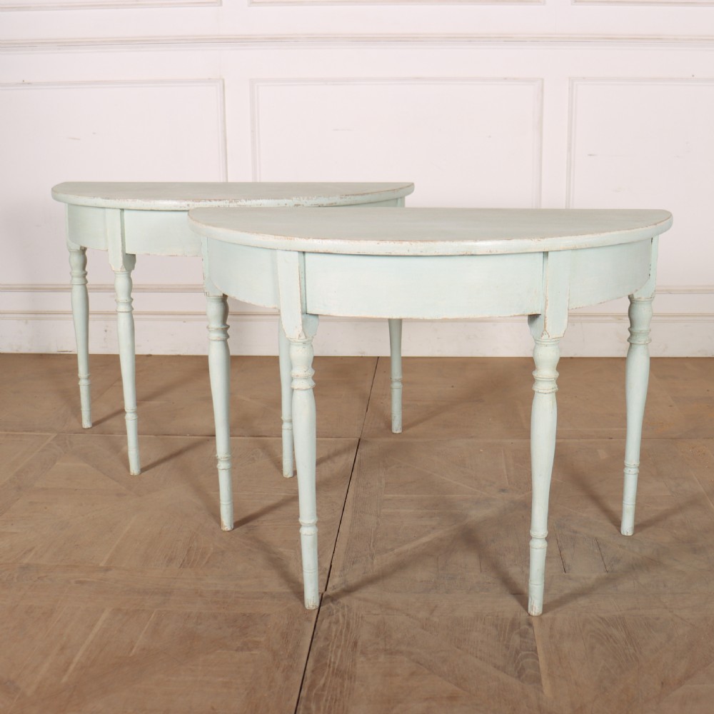 A pair of semi-circular Swedish console tables featuring pale green painted finishes, turned legs, and flat back edges. View II