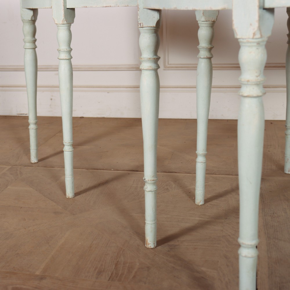 A pair of semi-circular Swedish console tables featuring pale green painted finishes, turned legs, and flat back edges. View IV