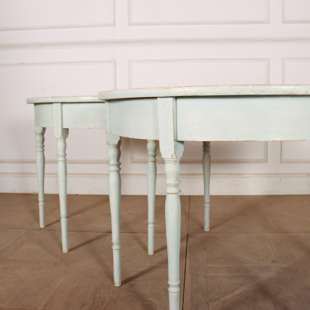 A pair of semi-circular Swedish console tables featuring pale green painted finishes, turned legs, and flat back edges. View V